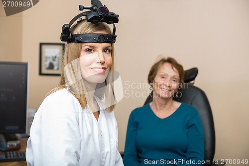 Image of Confident Female Optometrist With Senior Patient