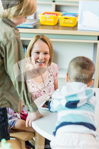 Image of Cheerful Teacher With Children In Library