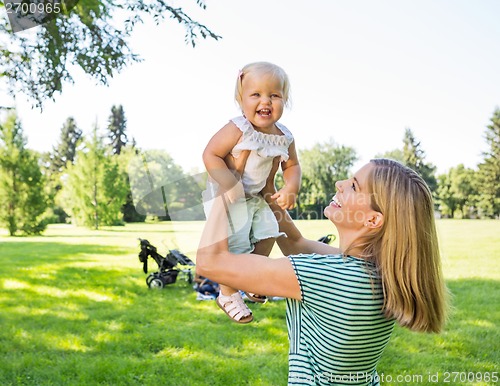 Image of Mother Lifting Daughter In Park