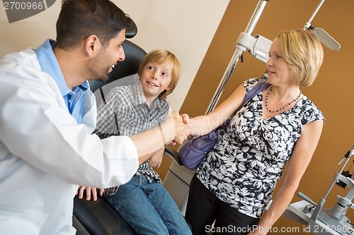 Image of Optician And Woman Shaking Hands By Boy