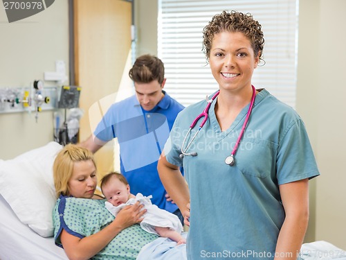 Image of Nurse Standing With Couple And Newborn Baby In Background
