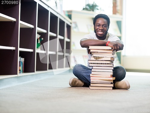 Image of Happy Student Leaning On Stacked Books In Library