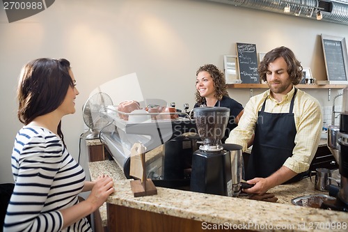 Image of Customer Looking At Baristas Making Coffee In Cafeteria