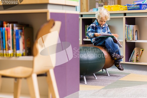Image of Schoolboy Reading Book In Library