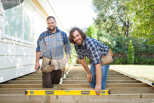 Image of Happy Construction Workers With Spirit Level At Site