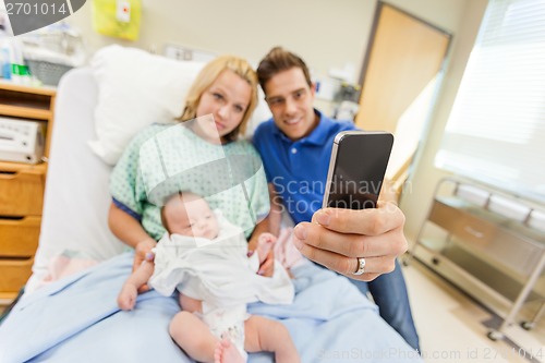 Image of Man With Woman And Babygirl Taking Selfportrait Through Cell Pho