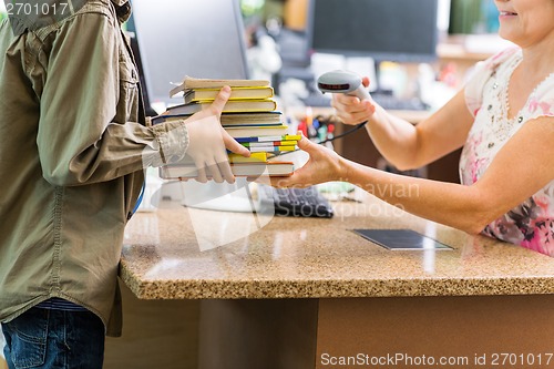 Image of Schoolboy Holding Books At Library Counter