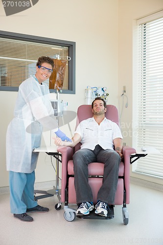 Image of Nurse Examining Patient Receiving Intravenous Treatment In Chemo