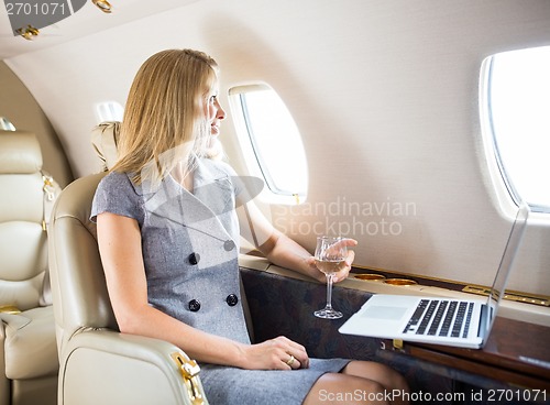 Image of Businesswoman Looking Through Window Of Private Jet