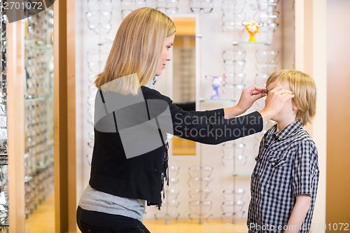 Image of Woman Trying Spectacles On Son At Shop