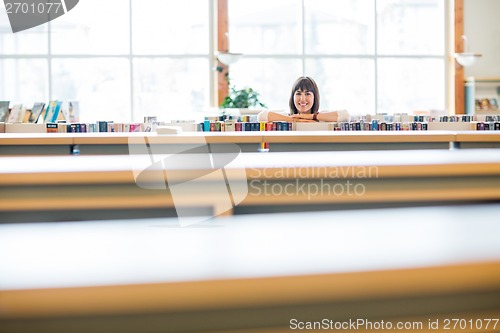 Image of Student Leaning In Books In Library