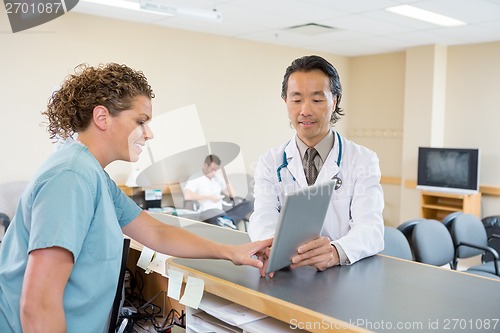 Image of Doctor And Nurse Using Digital Tablet At Hospital Reception