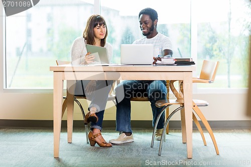 Image of Friends Using Technologies While Studying In Library