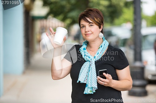 Image of Woman With Mobilephone And Coffee Cup Waving