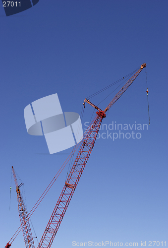 Image of Construction cranes against blue sky