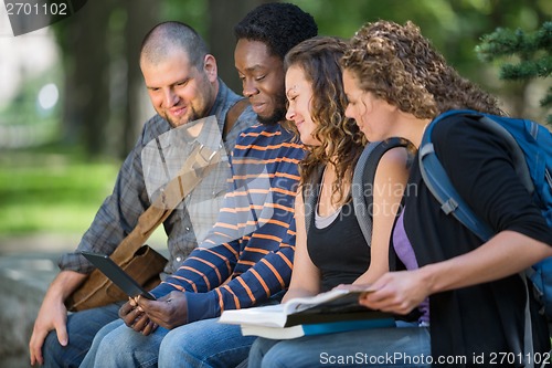 Image of Students Using Digital Tablet Together On Campus
