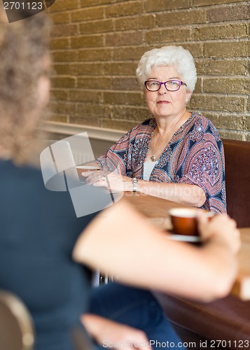 Image of Senior Woman With Friend In Coffeeshop