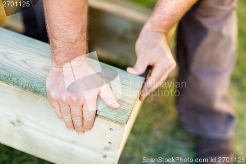 Image of Manual Worker's Hand Fixing Wood At Site