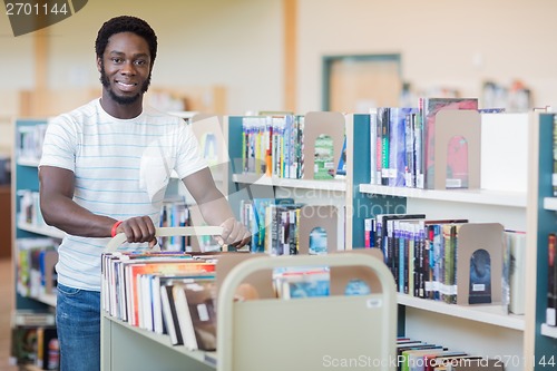 Image of Librarian With Trolley Of Books In Bookstore