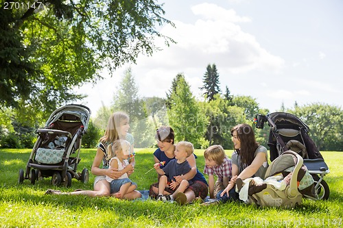 Image of Mothers And Children Enjoying Picnic In Park