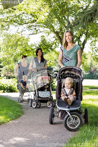 Image of Mothers Pushing Baby Strollers In Park