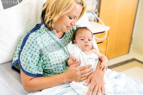 Image of Woman Looking At Babygirl On Hospital Bed