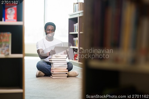 Image of Student With Books And Digital Tablet Sitting In Library