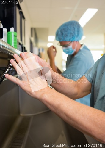 Image of Surgeons Scrubbing Hands With Colleague