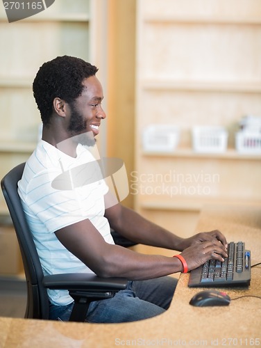 Image of Librarian Working On Computer At Library Desk