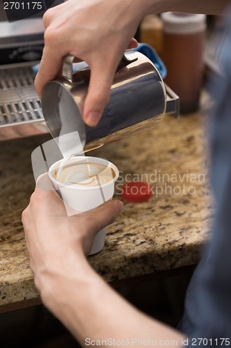 Image of Barista Making Design On Cappuccino In Coffeeshop