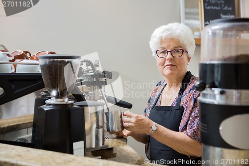Image of Senior Woman Steaming Milk with Espresso Machine