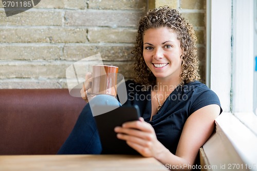 Image of Woman Using Digital Tablet In Cafe