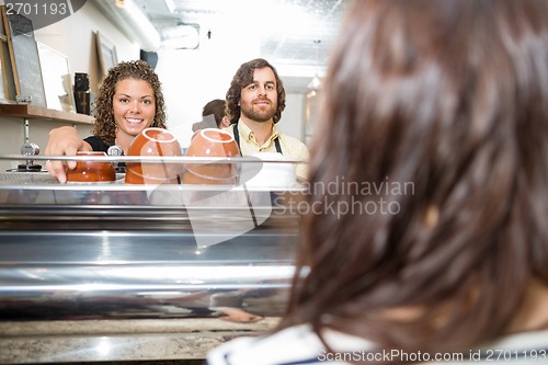 Image of Waitress Standing With Colleague At Coffeeshop Counter