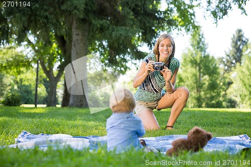 Image of Mother Taking Picture Of Baby Boy In Park