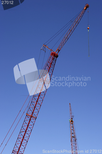 Image of Construction cranes against blue sky