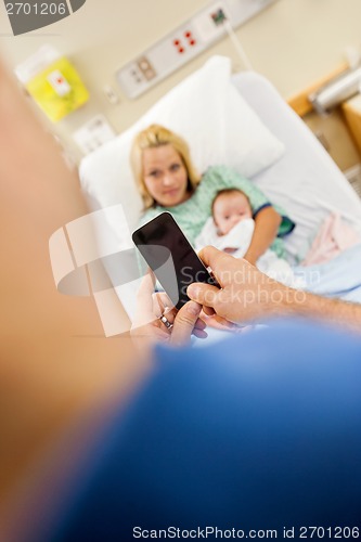 Image of Man Photographing Woman And Babygirl Through Mobile Phone