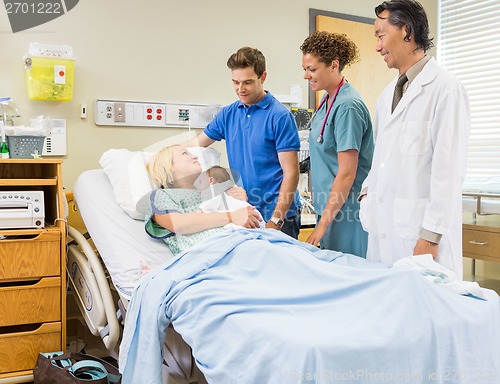 Image of Medical Team And Man Looking At Mother With Babygirl