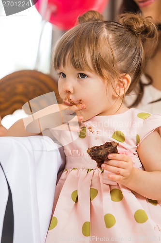 Image of Cute Girl Eating Cake With Icing On Her Face