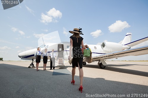 Image of Woman Walking Towards Private Jet At Airport Terminal