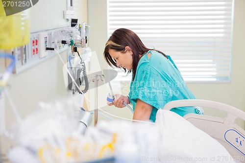 Image of Pregnant Woman Holding Nitrous Oxide Mask In Hospital Room