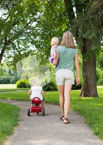 Image of Mother With Children Strolling In Park