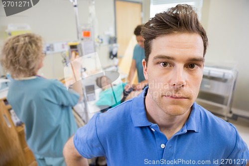 Image of Worried Man With Nurses Examining Pregnant Woman In Hospital