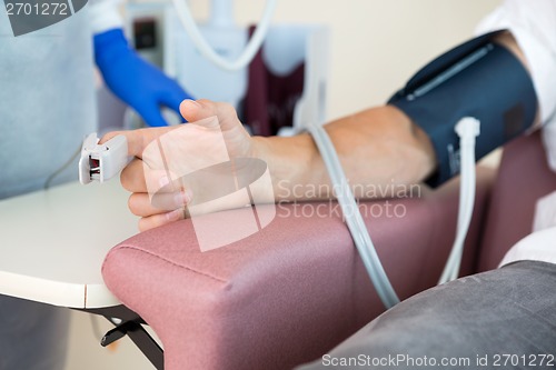 Image of Oximeter Attached To Male Patient's Finger In Hospital