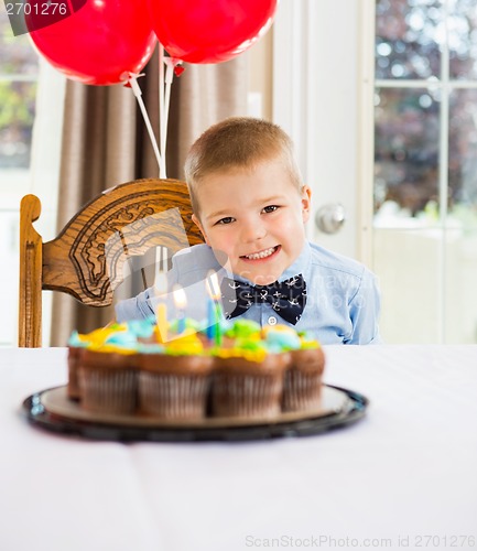 Image of Happy Boy Sitting In Front Of Birthday Cake