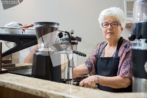 Image of Portrait of Senior Barista Preparing Coffee