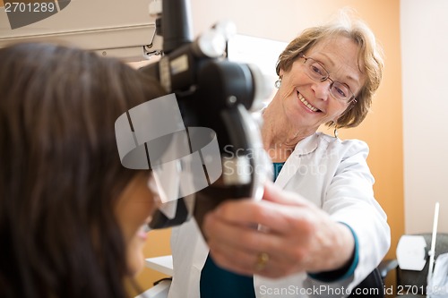 Image of Happy Optometrist Adjusting Phoropter For Patient