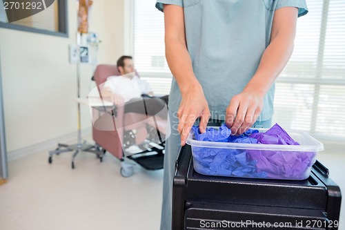 Image of Detail of Nurse Taking Gloves in Chemo Department