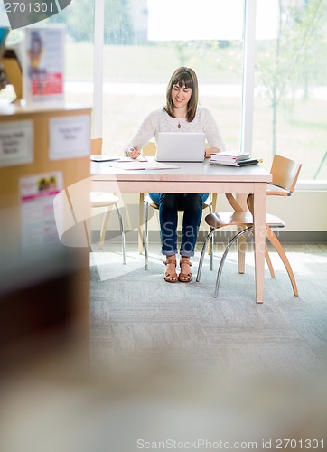 Image of Student With Laptop Writing Notes In Library