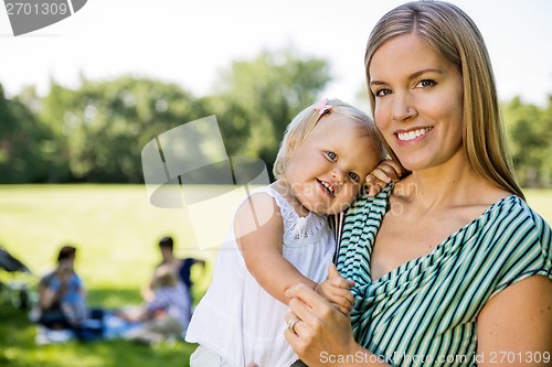 Image of Happy Mother Carrying Cute Daughter In Park