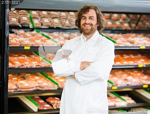 Image of Salesman Standing Arms Crossed In Butcher's Shop